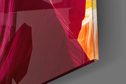 Close-up angled view of layered red and orange translucent glass panels with textured surfaces casting colored shadows.