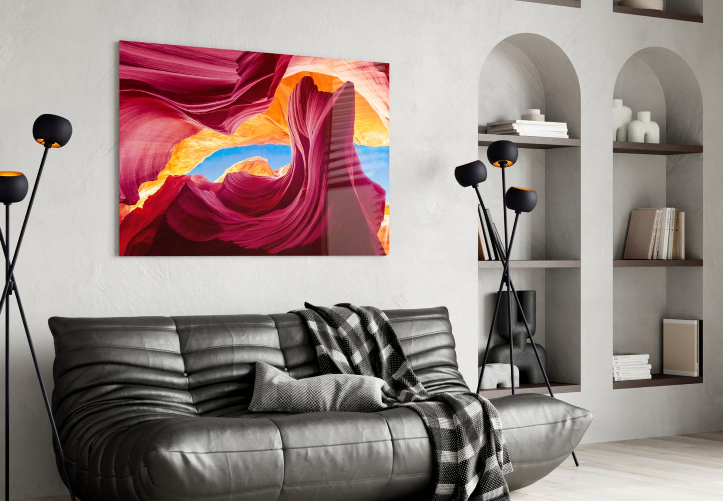 Red Valley Glass Wall Art displaying vibrant magenta and golden canyon formations hung above a gray leather sofa in modern interior.