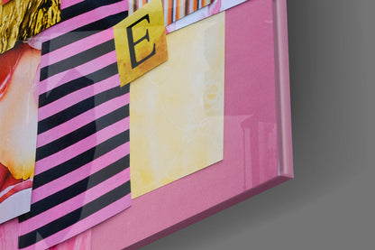 Close-up detail of pink glass wall art with black horizontal stripes, yellow letter "E," and cream-colored section.