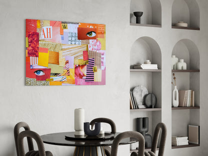 Colorful patchwork glass art featuring red, yellow, pink, and orange geometric patterns with eyes and text displayed above a black dining table in a modern interior.