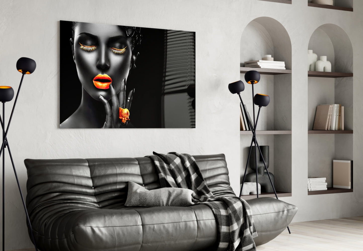 Black and orange glass wall art featuring a woman's face displayed above a gray leather sofa in a modern living room.