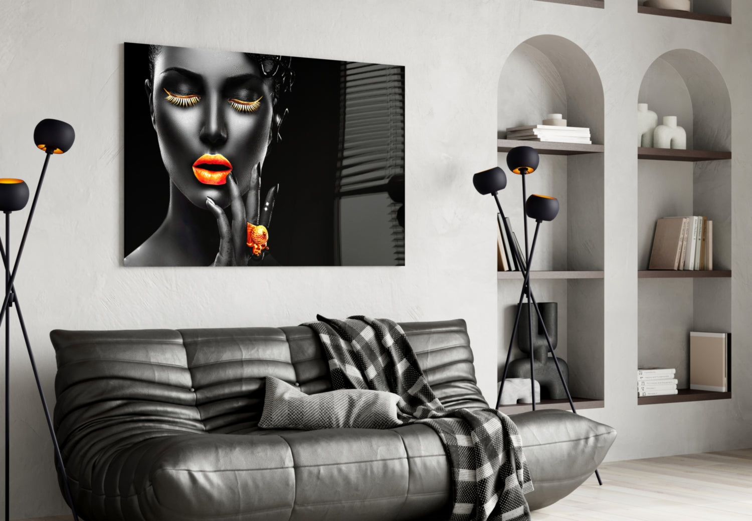 Black and orange glass wall art featuring a woman's face displayed above a gray leather sofa in a modern living room.