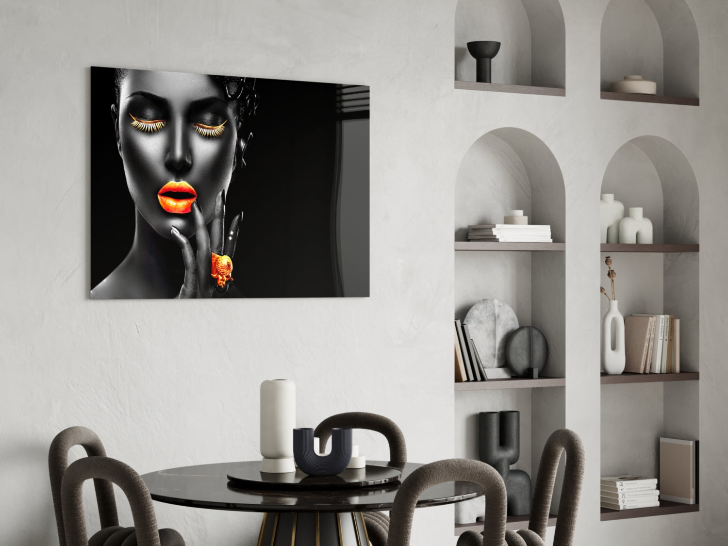 Modern dining room featuring black glass wall art of a woman's face with glowing orange lips and gold eyelashes above a round table.