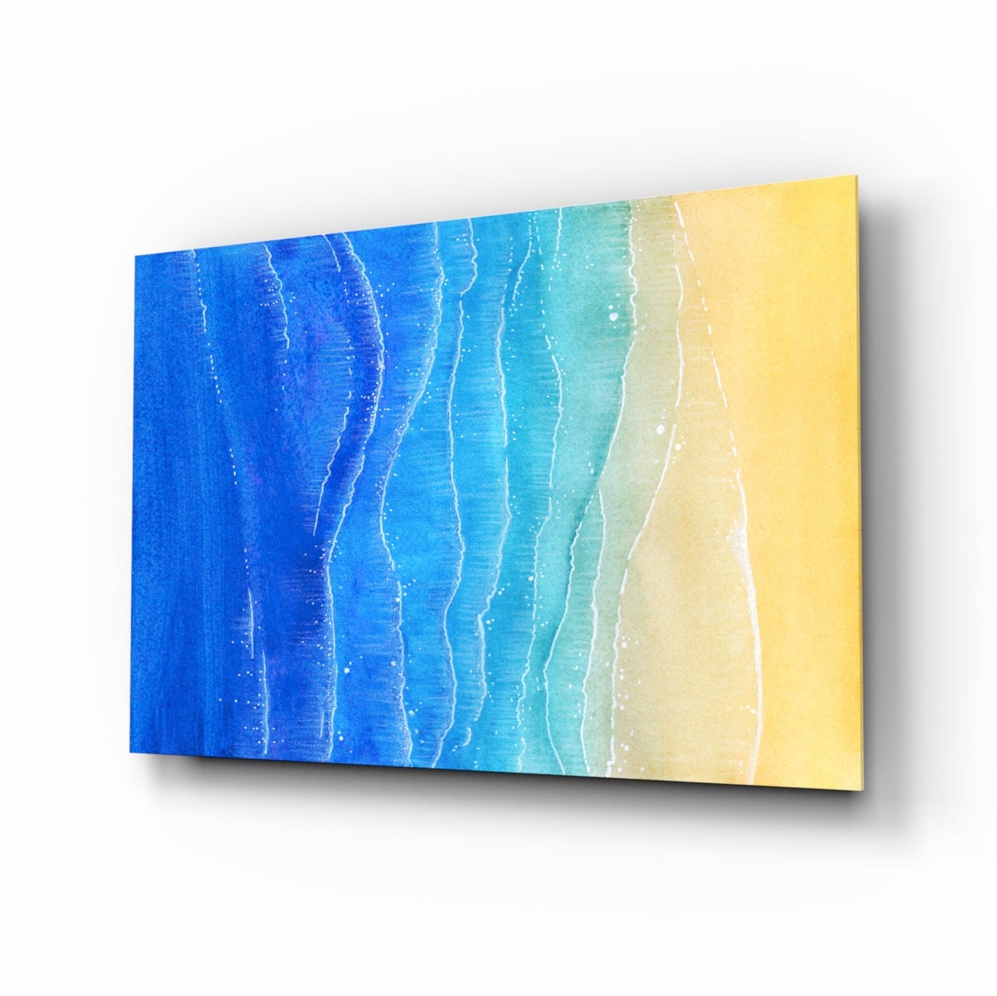 Angled perspective view of a glass wall art panel with gradient blue-to-yellow ocean waves and white foam details.
