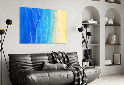 Sea Sand Glass Wall Art with blue-to-yellow gradient hung above black leather sofa in modern living room.