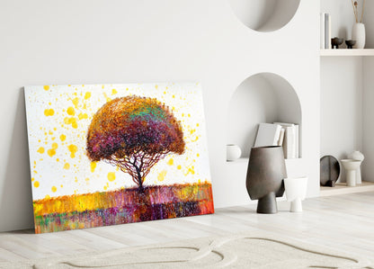 Colorful tree glass wall art leaning against white wall in minimalist room with sand patterns and decorative objects.