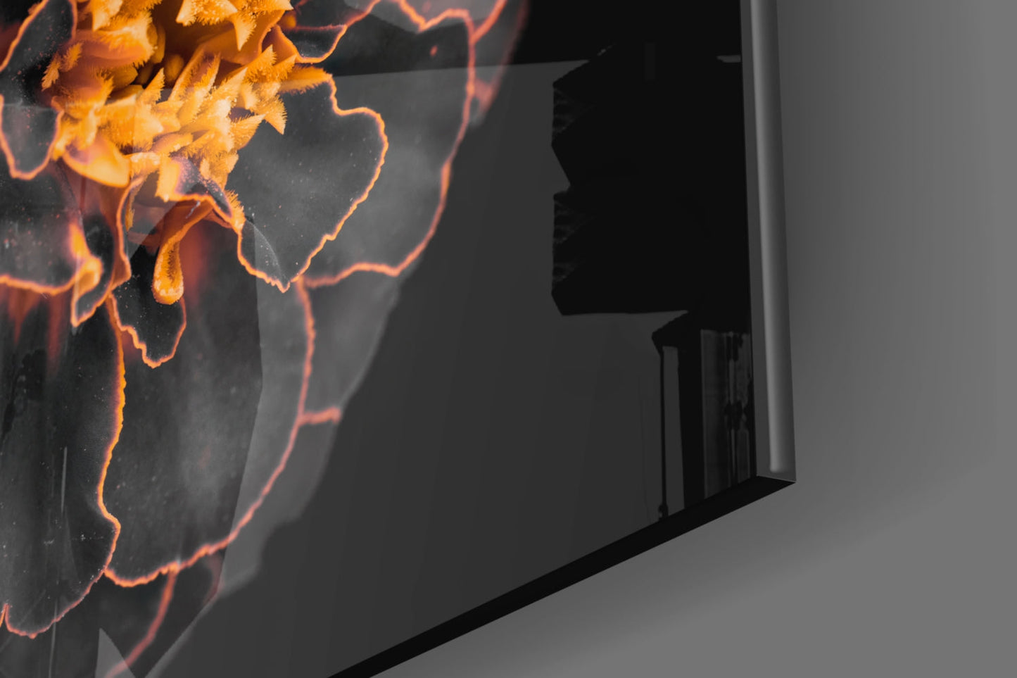 Angled view of brown flower glass wall art displaying orange and yellow petals with glowing edges against dark background.