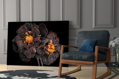 Brown flower glass wall art with orange-edged petals displayed in modern living room next to wooden chair.