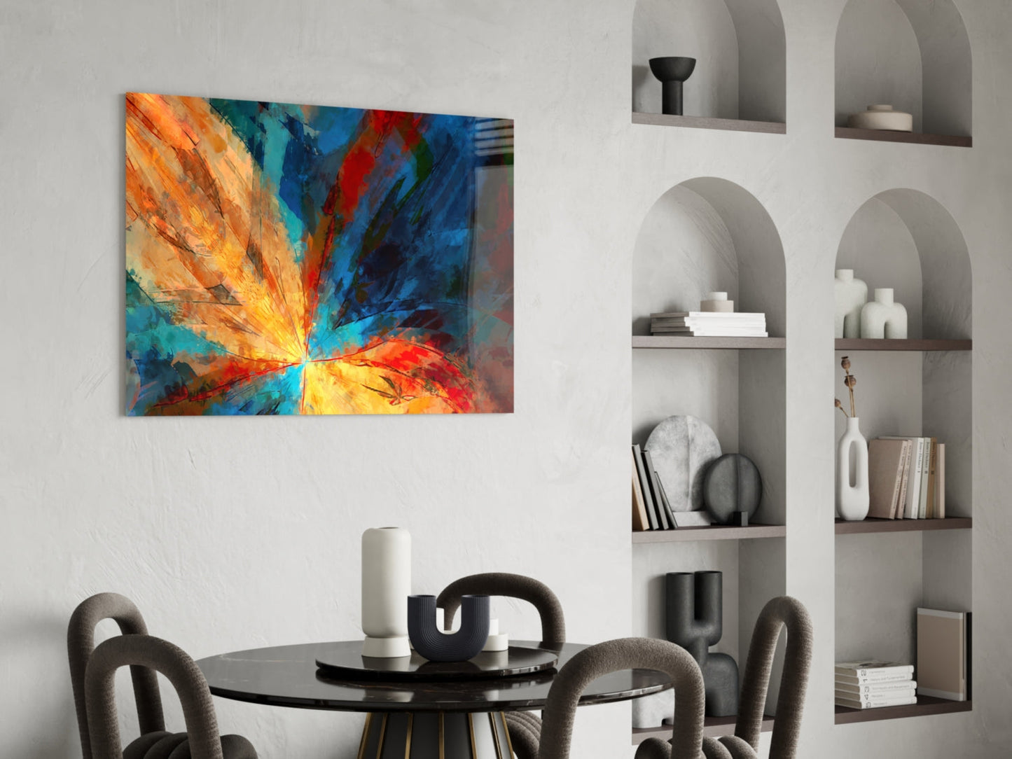 Vibrant abstract fractal flower glass art with orange, yellow, blue and red radiating rays displayed above a modern dining table.