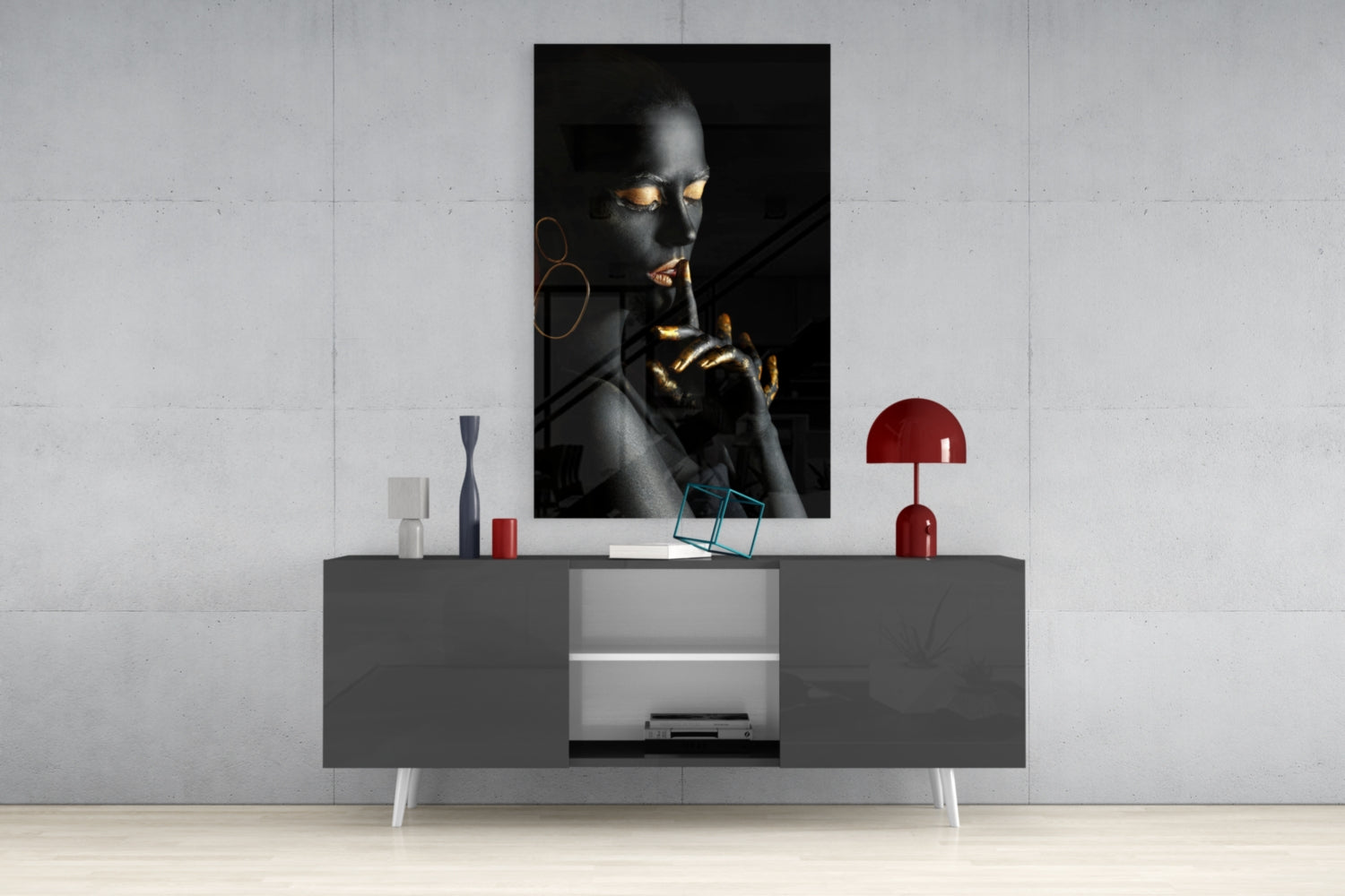 Portrait glass wall art depicting a dark-skinned woman with gold accents displayed above a gray media console in a minimalist interior setting.