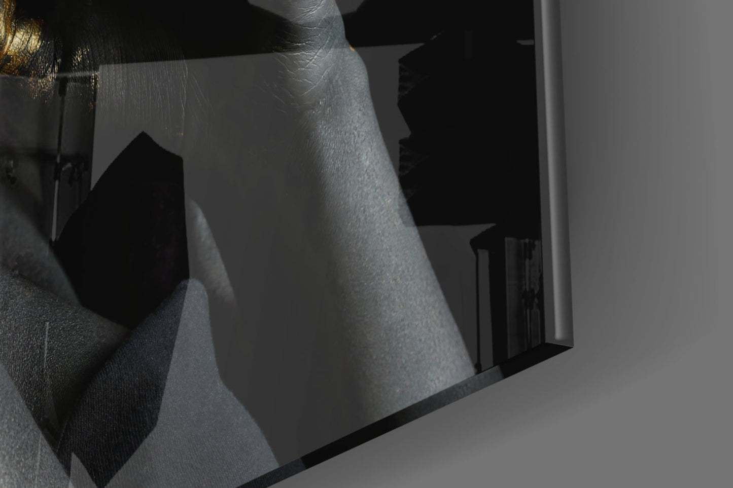 Close-up angled view of frosted glass wall art with silhouetted female profile and gold accent detail against black background.