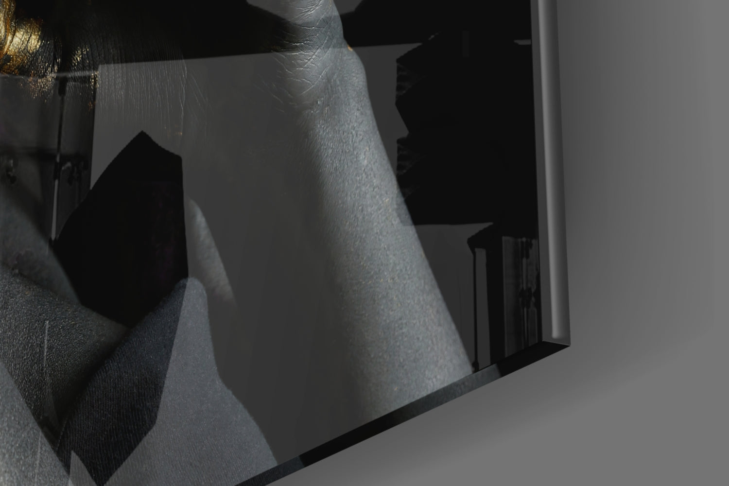 Close-up angled view of frosted glass wall art with silhouetted female profile and gold accent detail against black background.
