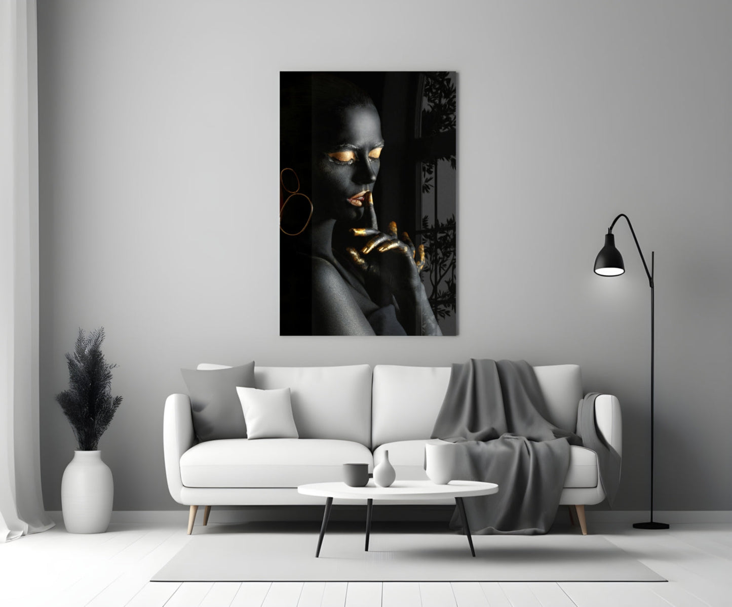 Silent Woman Glass Wall Art displayed above a white sofa in a minimalist living room, featuring a portrait with gold accents on black background.