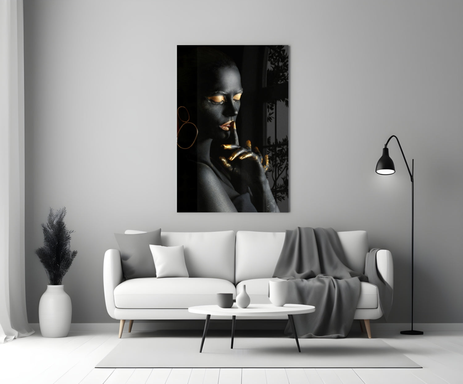 Silent Woman Glass Wall Art displayed above a white sofa in a minimalist living room, featuring a portrait with gold accents on black background.