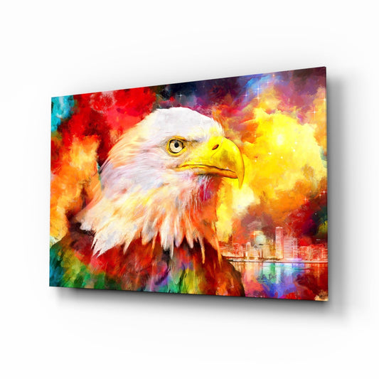 Angled view of glass wall art featuring a bald eagle's head against vibrant multicolored abstract background with cityscape, displayed on white surface.