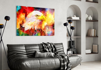 Vibrant glass wall art depicting an eagle's head in multicolored flames displayed above a black leather sofa in a modern living room.