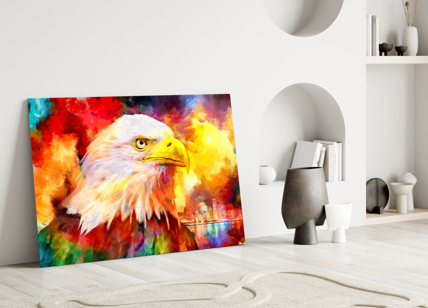 Colorful eagle glass wall art leaning against white wall in minimalist interior with shelving and decorative objects.