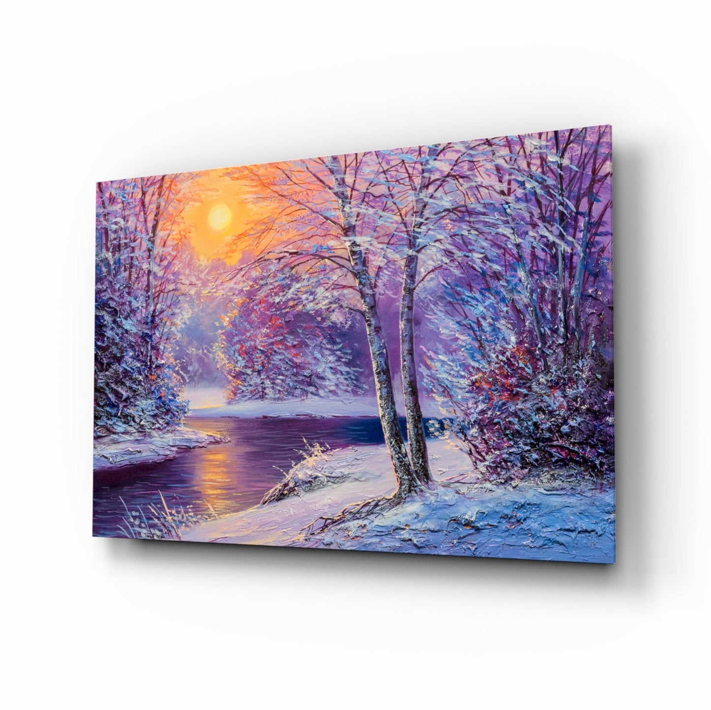 Glass wall art displaying a snow-covered forest path beside a frozen river at sunset, with purple, blue, and golden tones.