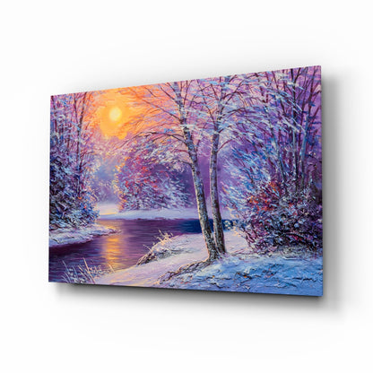 Glass wall art displaying a snow-covered forest path beside a frozen river at sunset, with purple, blue, and golden tones.