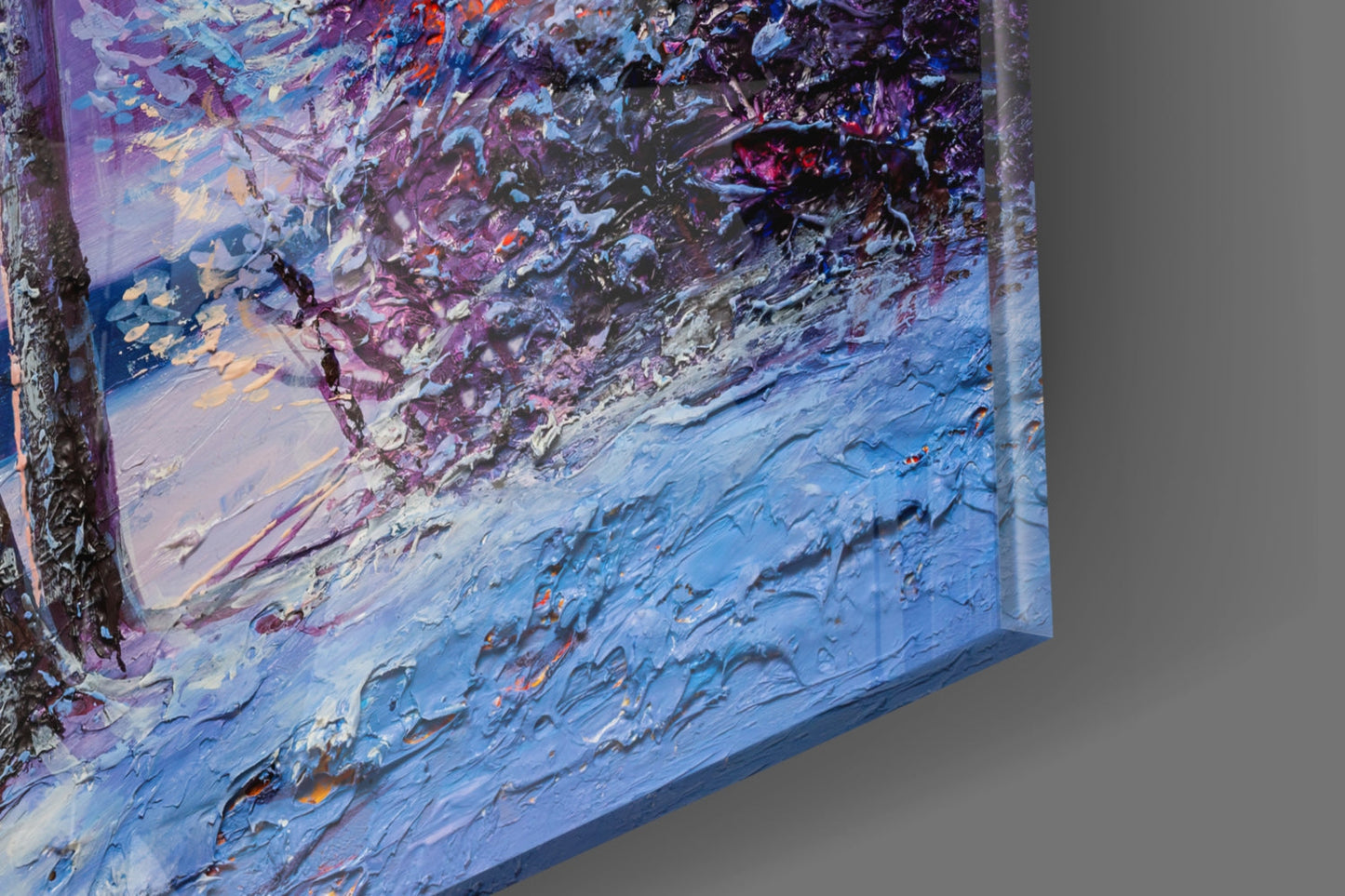 Close-up angled view of textured glass wall art with thick impasto brushstrokes in blue, purple, pink, and white paint.