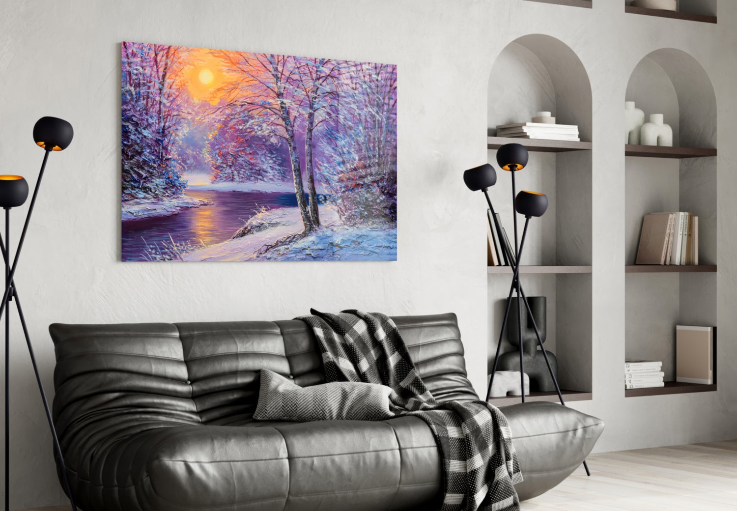 Glass wall art depicting a snowy forest landscape with purple trees, golden sunset, and frozen river displayed above a black leather sofa in a modern living room.