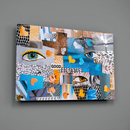 Abstract Confusion Glass Wall Art displayed at an angle, revealing colorful patchwork squares with eyes, hearts, patterns, and "GOOD" text in blue, orange, and neutral tones.