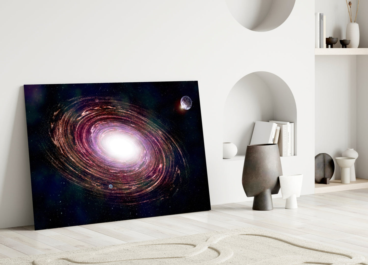 Galaxy glass wall art leaning against white wall in minimalist interior with decorative objects and shelving.