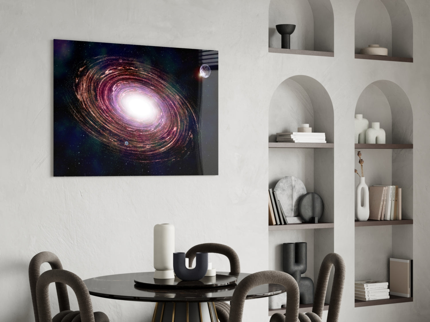 Glass wall art depicting a purple and gold spiral galaxy with bright center, hung above a round black dining table with gray chairs.