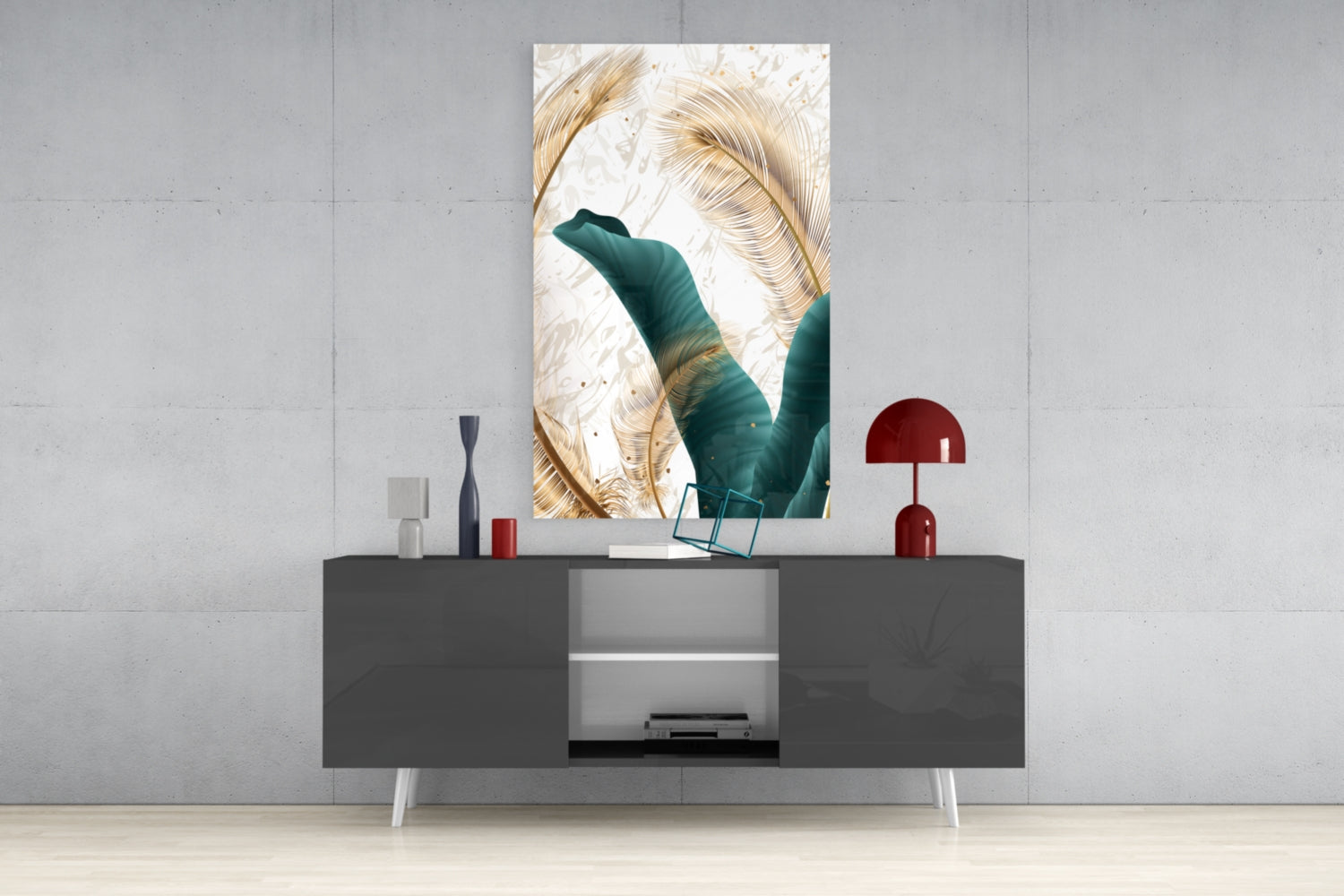 Vertical glass wall art featuring golden feathers and teal green leaves displayed above a dark console table with red decorative lamp.