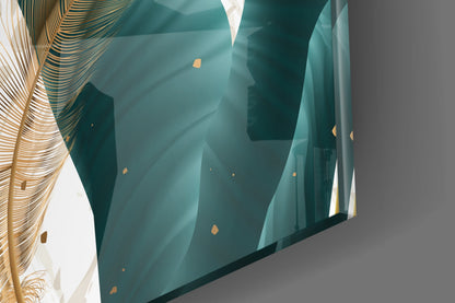 Angled view of teal glass wall art with geometric leaf patterns and gold accents, mounted on gray wall with decorative gold foliage visible on left.