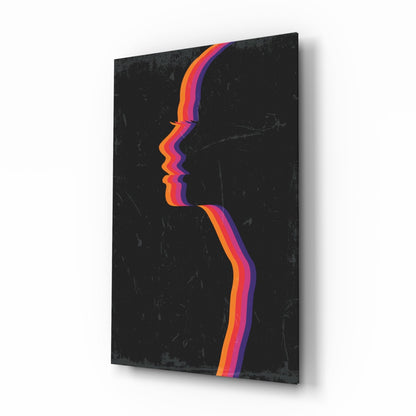 Angled view of black glass wall art with colorful layered silhouette profile in orange, pink, and purple stripes.