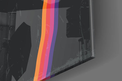 Angled perspective view of Night Filter Glass Wall Art displaying vertical stripes in orange, red, pink, and purple over grayscale architectural imagery.