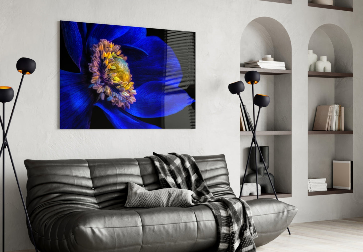 Blue and yellow flower glass wall art displayed above black leather sofa in modern living room interior.