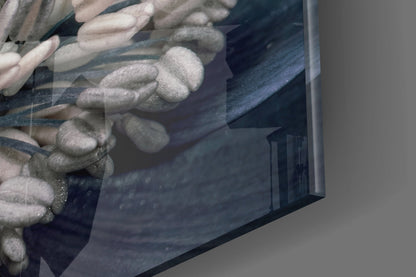 Close-up angled view of gray flower glass wall art showing textured floral relief details and dark blue-gray tones on glass surface.