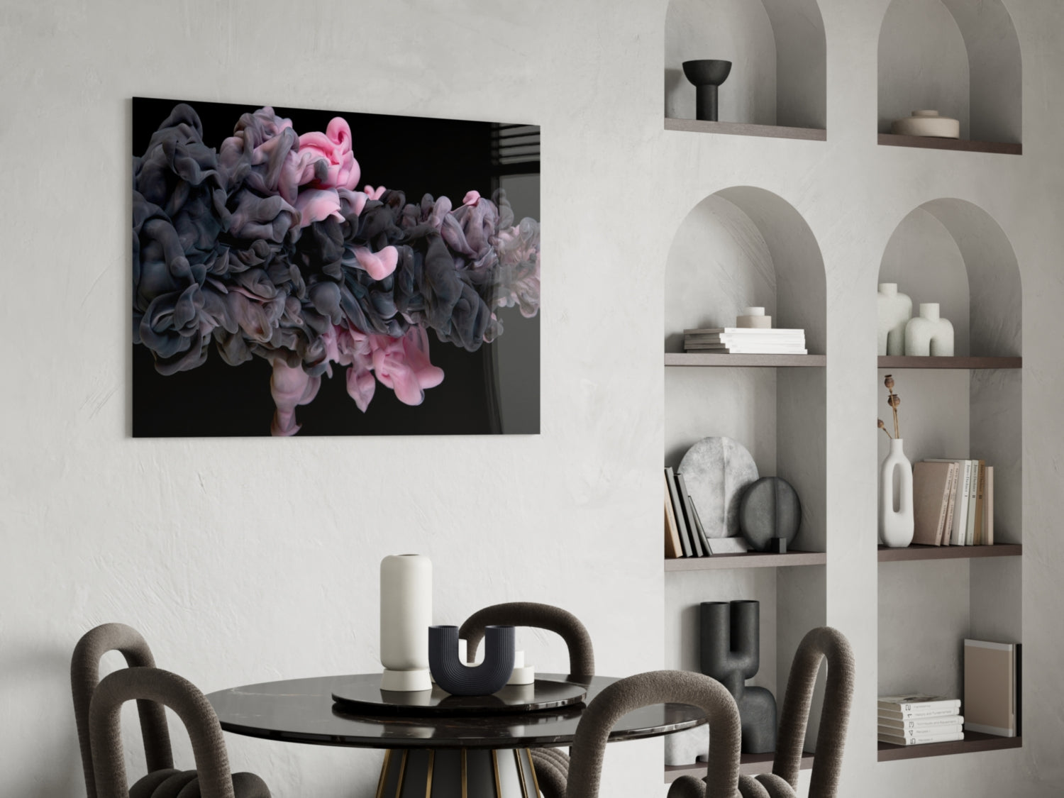 Pink and black swirling smoke design on glass art displayed above black dining table in modern interior with white built-in shelving.