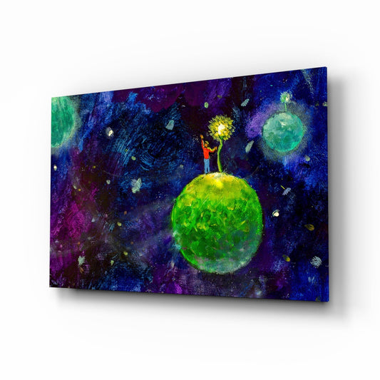 Glass wall art displaying a figure in red standing on a luminous green planet, reaching toward a yellow sun, against a deep blue and purple cosmic background with scattered stars and celestial bodies.