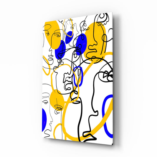 Angled front view of glass wall art featuring continuous line face drawings in black with yellow and blue colored sections on white background.