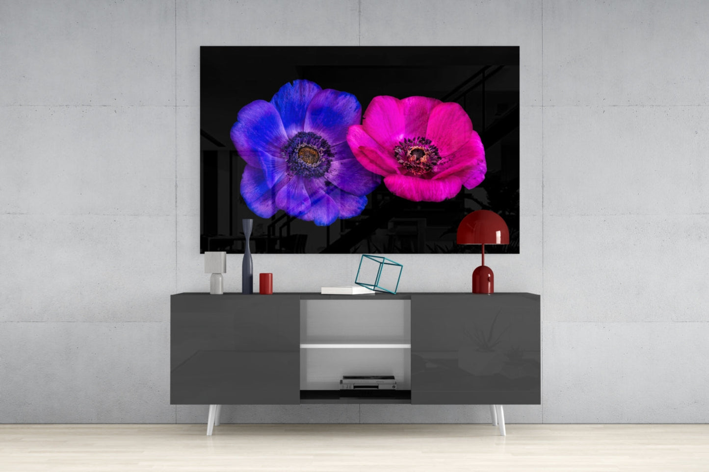 Modern living room setup with wall-mounted TV displaying vibrant blue and pink flowers against black background, styled above gray media console with white legs.