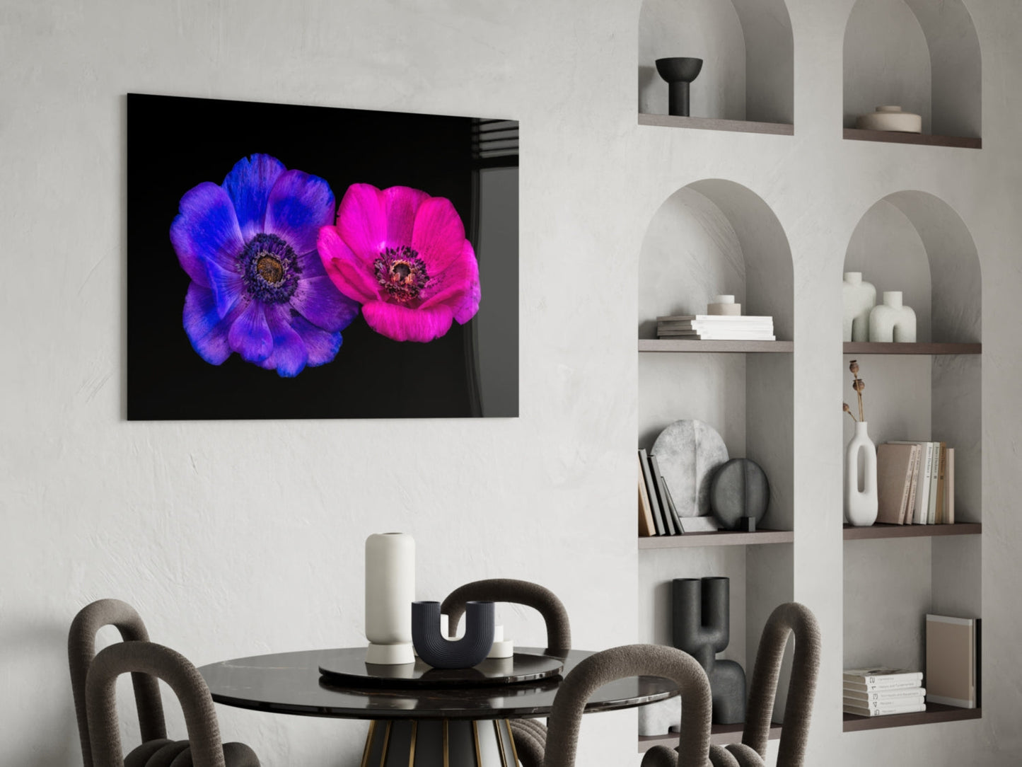 Glass wall art featuring vibrant blue and magenta flowers on black background, displayed above a modern dining table with chairs and built-in shelving.
