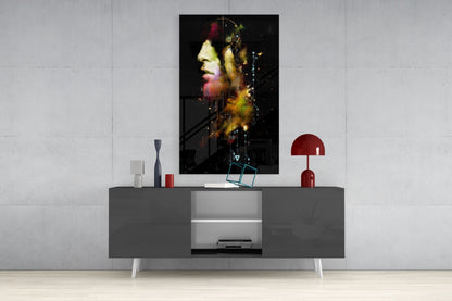 Colorful portrait glass art with yellow and red tones displayed above gray media console in modern living room setting.