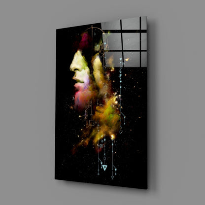 A glass wall art panel displaying a profile portrait with colorful powder effects and geometric line designs on a black starry background.