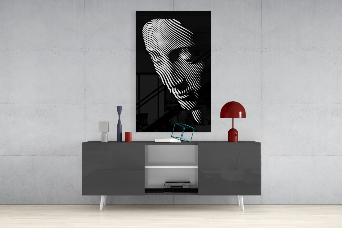 Black and white striped portrait artwork displayed above gray media console with red lamp and decorative accessories in modern interior setting.