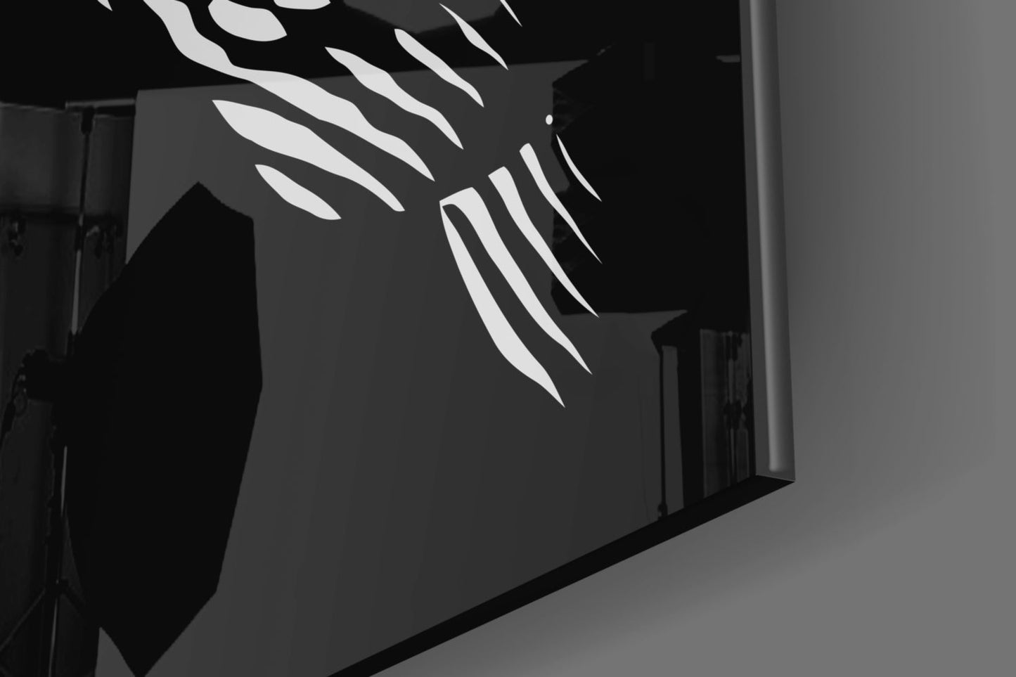 Black and white glass wall art with white feather design mounted on dark wall, angled installation view.