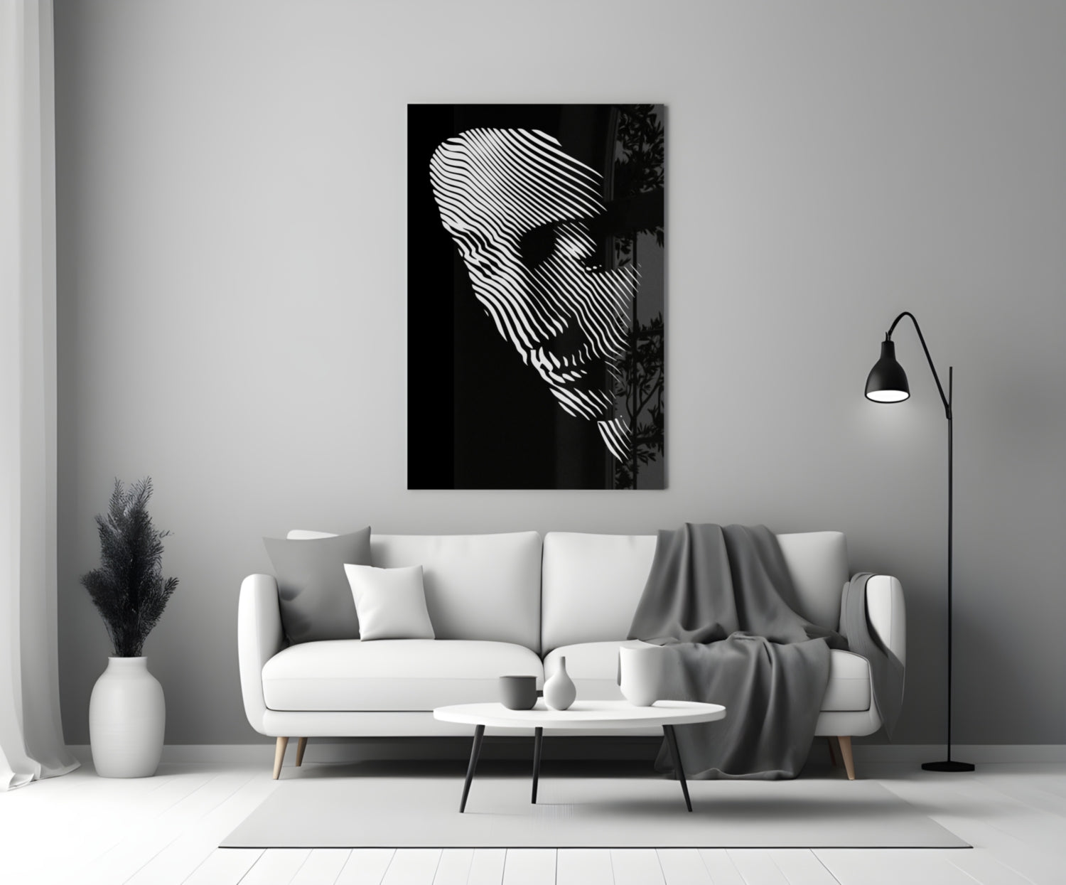 Black and white glass wall art featuring abstract striped face portrait displayed above white sofa in minimalist living room setting.