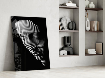 Black and white striped face portrait leaning against white wall beside built-in shelving with decorative objects and books.