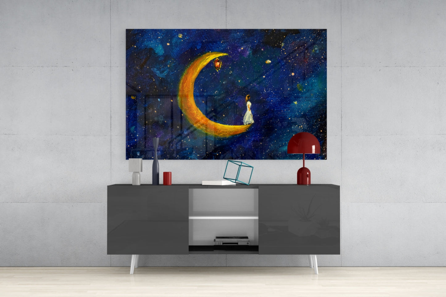 Moon House Glass Wall Art displaying a glowing golden crescent moon with a figure in white dress against a starry night sky, mounted above a dark gray media console.