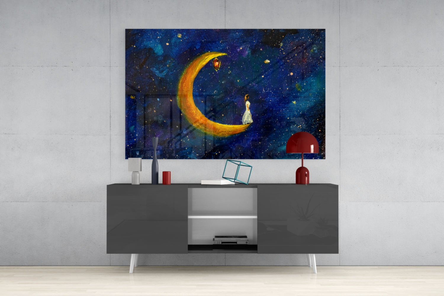 Moon House Glass Wall Art displaying a glowing golden crescent moon with a figure in white dress against a starry night sky, mounted above a dark gray media console.