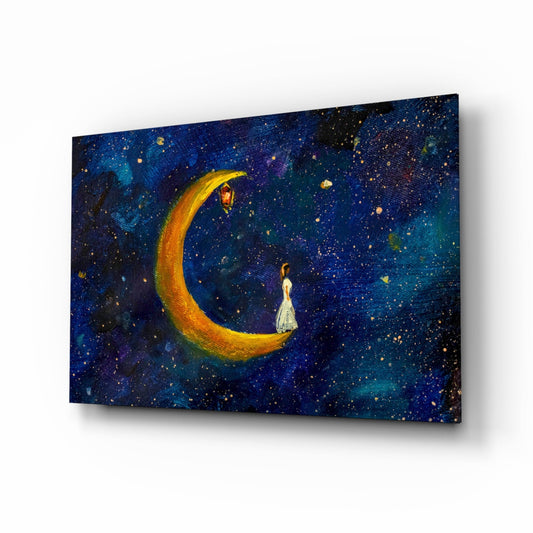 Glass wall art panel displaying a figure in white dress sitting on a glowing golden crescent moon against a deep blue starry night sky.
