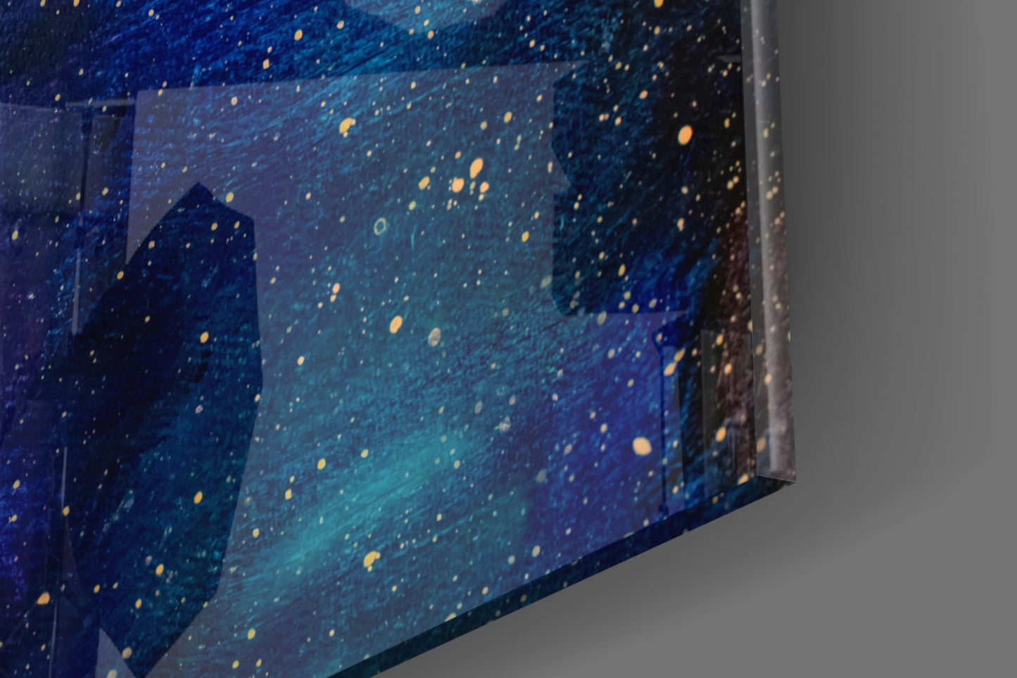 Close-up angled view of glass wall art displaying deep blue night sky with golden scattered stars and silhouetted buildings.