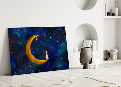 Glass wall art leaning against white wall displays golden crescent moon with figure against deep blue starry night sky background.